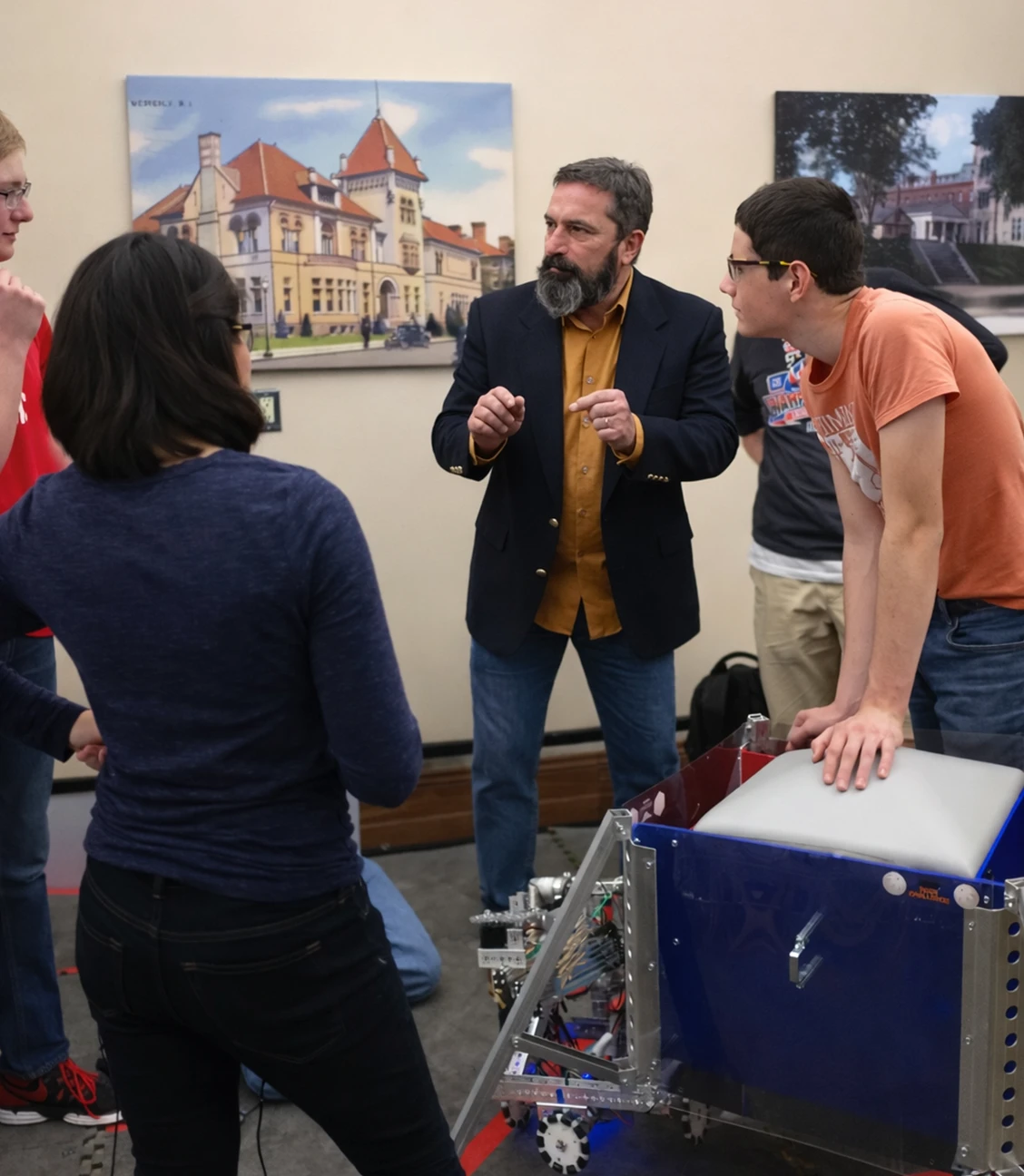 A patent agent guides students discussing a robotics project, fostering innovation and collaboration in patent strategies.
